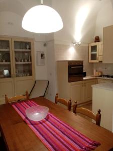 uma cozinha com uma mesa de madeira e uma sala de jantar em LA CASA DI TITTA em Pantelleria