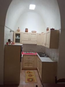una cocina con armarios blancos y un arco sobre el fregadero en LA CASA DI TITTA en Pantelleria