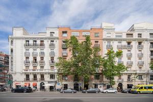 um grande edifício com carros estacionados em frente em For You Rentals Duplex with Private Patio in the Center of Madrid MPE35 em Madri