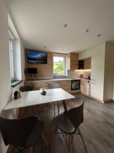 a large kitchen with a white table and chairs at Apartmán Nad Úpou in Pec pod Sněžkou