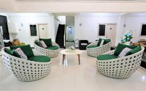 a living room with green chairs and a table at Gading Guest House in Mataram