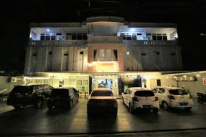 Gading Guest House في ماتارام: موقف للسيارات مع وقوف السيارات أمام المبنى