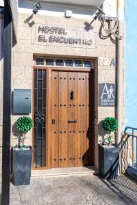 uma porta de madeira num edifício com um sinal em Albergue El Encuentro em Villanueva de la Vera