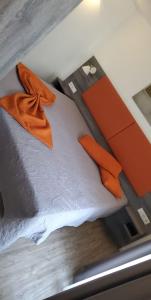 ein Bett mit orangefarbenen Handtüchern darüber in der Unterkunft Villa Katzenbuckel in Waldbrunn