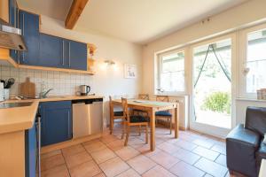 a kitchen with blue cabinets and a table and chairs at Haus Selene in Neu Sallenthin