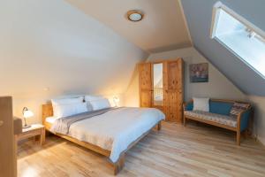 a bedroom with a bed and a bench in a attic at Haus Selene in Neu Sallenthin