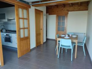 a kitchen and dining room with a table and chairs at La Casuca de Rosi en Suances in Suances