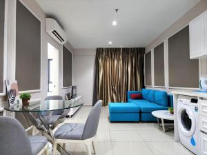 a living room with a blue couch and a glass table at Cozy Suite @ I-City in Shah Alam