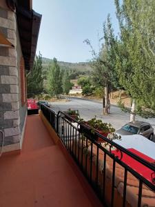 een balkon met een zwart hek en een straat bij La alacena de Jose y Rosi in Güéjar-Sierra