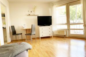 a bedroom with a television and a desk with chairs at 1 Zimmer Apartment mit Balkon in Glauchau