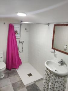 GorafeにあるCueva Navarroのピンクのシャワーカーテンとシンク付きのバスルーム