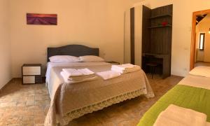 Residence il giardino sul fiume Nera في Cerreto di Spoleto: غرفة نوم بها سريرين مع مناشف عليهما