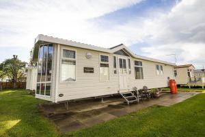a large white house with a patio in a yard at Great 6 Berth Caravan By The Beach At California Cliffs In Scratby Ref 50010l in Great Yarmouth