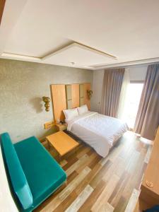 una camera con letto e sedia blu di Hotel Atlantis Mazagan a Douar Draoud