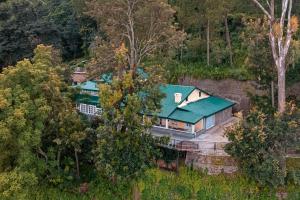une vue aérienne sur une maison avec un toit vert dans l'établissement StayVista at Springfield with Scenic Lawn, à Kasauli