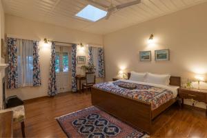 a bedroom with a bed and a desk in it at StayVista at Springfield with Scenic Lawn in Kasauli