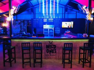 曼谷的住宿－Wild Ones Hostel，一间酒吧,在一间房间里设有四把酒吧凳