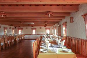 a long dining room with tables and chairs at Tourist Farm Rooms Lovrec in Jiršovci