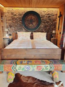 łóżko w pokoju z zegarem na ścianie w obiekcie Villa Bosca - Adults Only w mieście Predazzo