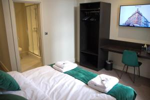 um quarto de hotel com uma cama com toalhas em Keystone House em Londres