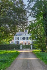 una entrada que conduce a una gran casa blanca en De Heerlijkheid Loenen Bed en Breakfast en Slijk-Ewijk