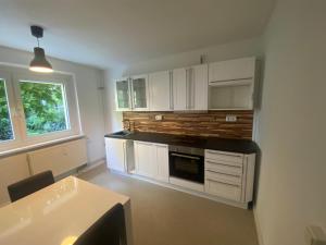 a kitchen with white cabinets and a stove top oven at Osthafen II in Berlin