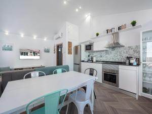 a kitchen and dining room with a white table and chairs at La Isla , tu hogar en Torre del Mar. in Torre del Mar +55 photos