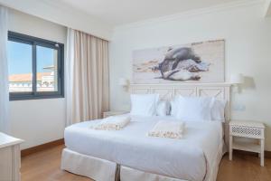 a bedroom with a large white bed and a window at Iberostar Selection Andalucia Playa in Chiclana de la Frontera