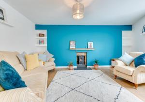 a blue living room with couches and a fireplace at An Rannji in Penzance