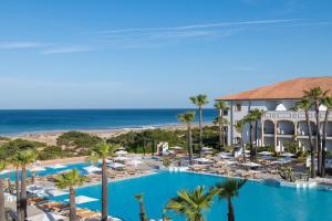 a view of a resort with a swimming pool and the beach at Iberostar Selection Andalucia Playa in Chiclana de la Frontera