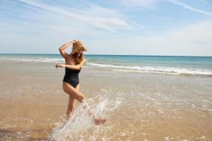 a woman is walking on the beach at Iberostar Selection Andalucia Playa in Chiclana de la Frontera