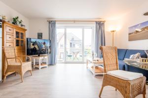 een woonkamer met een blauwe bank en stoelen bij Haus Hauke Whg 8 in Westerland