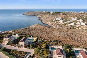 una vista aérea de una casa y del océano en Magnifique villa avec piscine au bord de mer, en Chorafakia