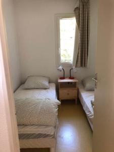 two beds in a small room with a window at House near the ocean and forest in Soulac-sur-Mer