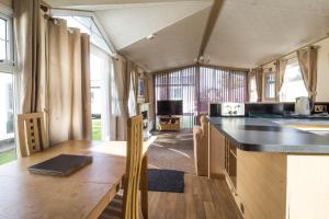 a kitchen and dining area of an rv at Great 6 Berth Caravan By The Beach At California Cliffs In Scratby Ref 50010l in Great Yarmouth