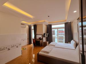 ein Hotelzimmer mit einem Bett und einem Fenster in der Unterkunft Khách Sạn Cốc Cốc in Rạch Giá