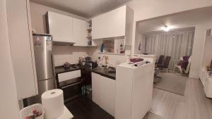 een kleine keuken met witte kasten en een koelkast bij White Pearl Residence in Sarajevo