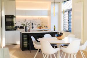 a kitchen with a white table and white chairs at Wellness guesthouse Passendale ***** in Zonnebeke