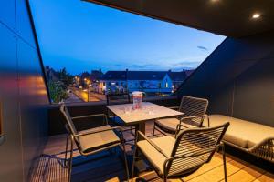 balcón con mesa, sillas y sofá en Wellness guesthouse Passendale *****, en Zonnebeke