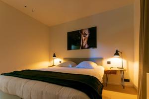 a bedroom with a large bed with a tv on the wall at Wellness guesthouse Passendale ***** in Zonnebeke