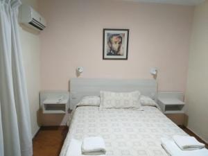 a bedroom with a white bed with two towels on it at Regine Hotel in San Rafael +50 photos