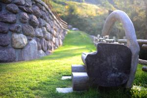 Orobie Alps Resort في Roncobello: وجود تمثال للغلاية جالس بجانب جدار حجري