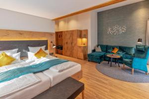 ein Schlafzimmer mit einem großen Bett und einem Sofa in der Unterkunft Hotel Langenwaldsee in Freudenstadt