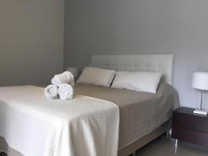 a bedroom with a bed with two towels on it at Green Park in Punta del Este