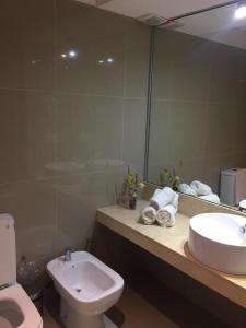 a bathroom with a sink and a toilet and a mirror at Green Park in Punta del Este