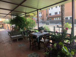 a patio with a table and chairs and plants at Le camere di aisa in Santa Maria degli Angeli
