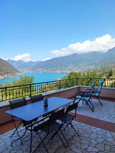 a table and chairs on a balcony with a view of a lake at Lake Iseo - Gli ulivi 1 in Sulzano
