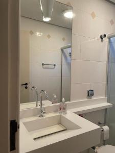 uma casa de banho com um lavatório e um espelho em BEIRA DA PRAIA com VISTA TOTAL DO MAR em Florianópolis