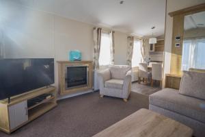 a living room with a flat screen tv and a couch at Beautiful 6 Berth Caravan At Suffolk Sands Holiday Park Ref 45010mv in Felixstowe