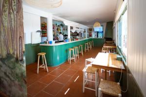 a restaurant with a green counter and wooden tables and stools at Kampaoh Cazorla in El Valle